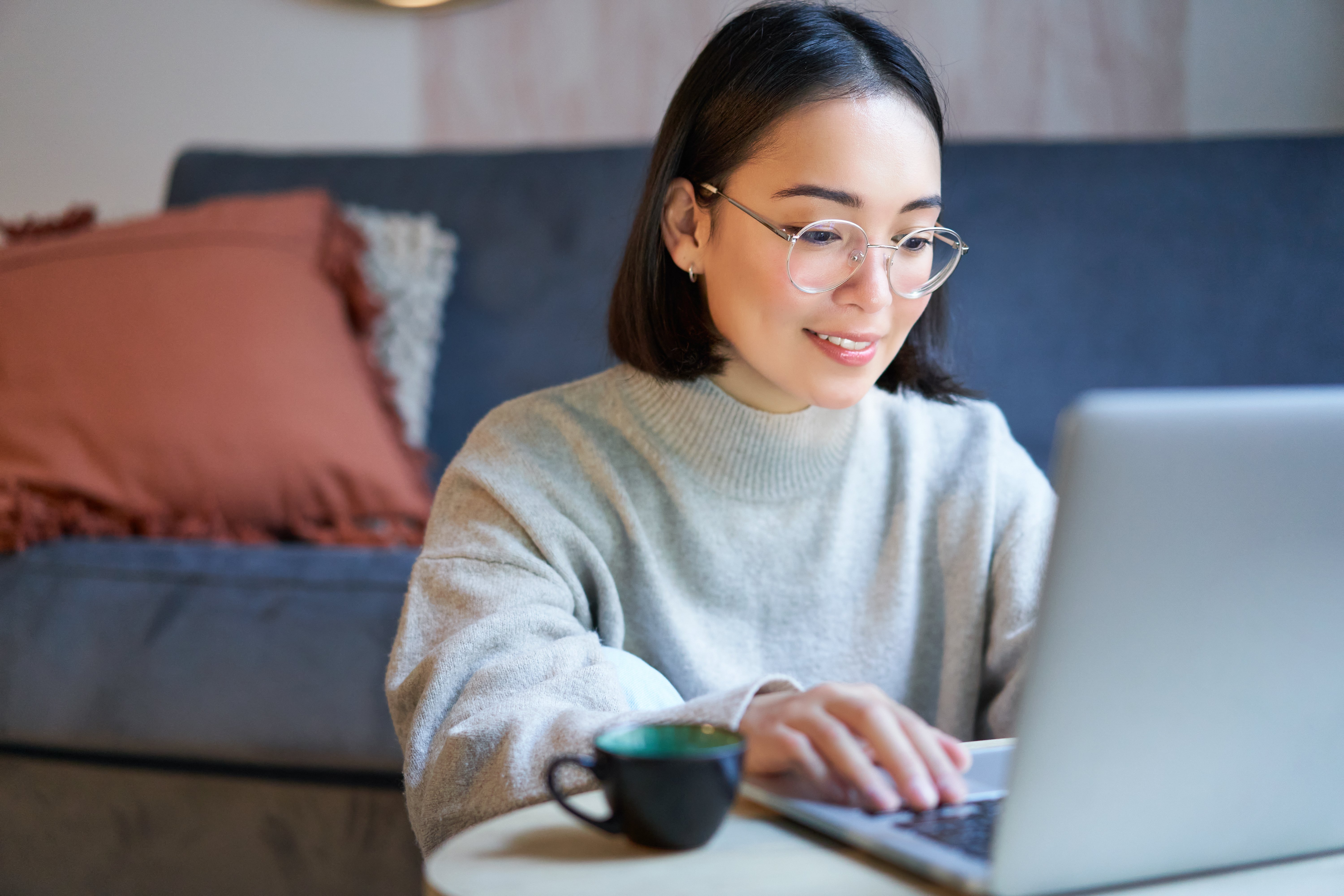 portrait-smiling-asian-girl-working-from-home-staying-remote-using-laptop-studying-her-comp